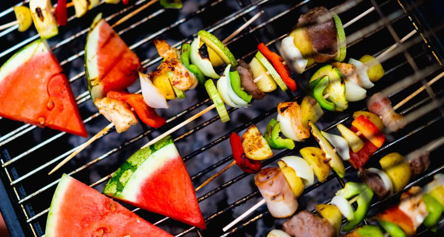 Spieße und Melone auf Grillrost