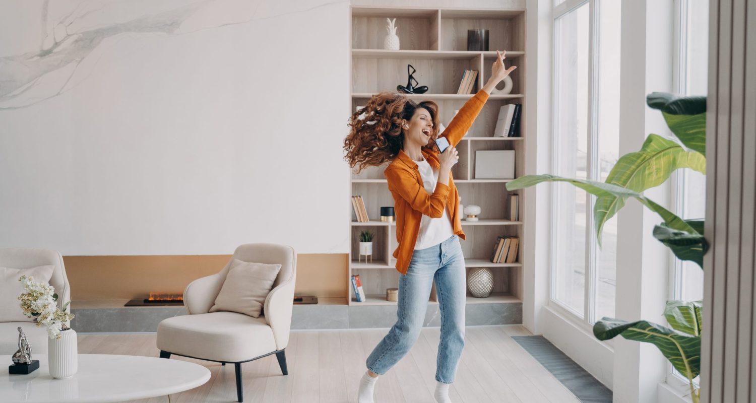 femme qui danse en écoutant de la musique dans son salon