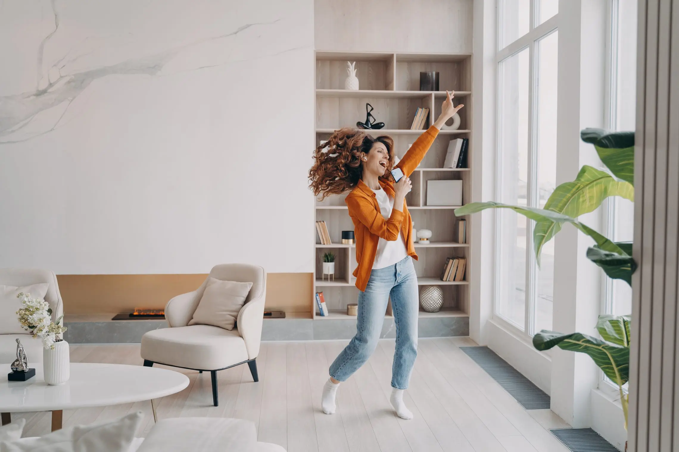 femme qui danse en écoutant de la musique dans son salon