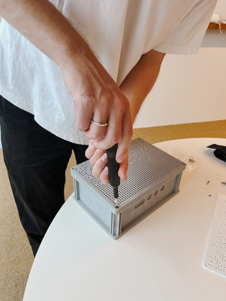 homme bricole sur l'enceinte MYND Teufel pour accéder aux composants internes
